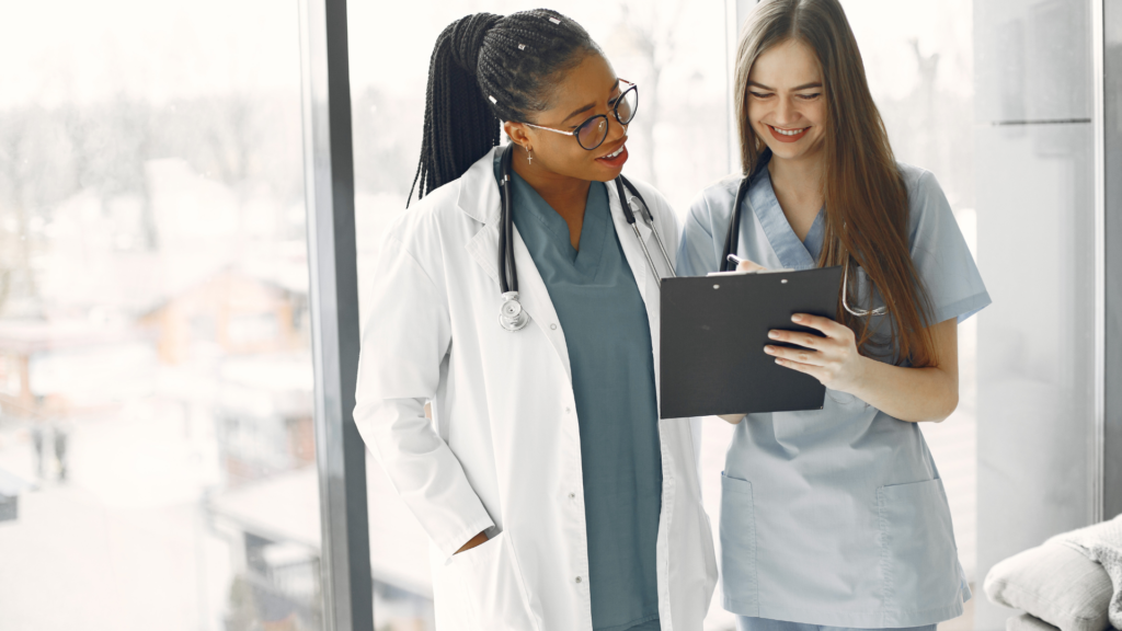Two female healthcare workers engaged in discussion.